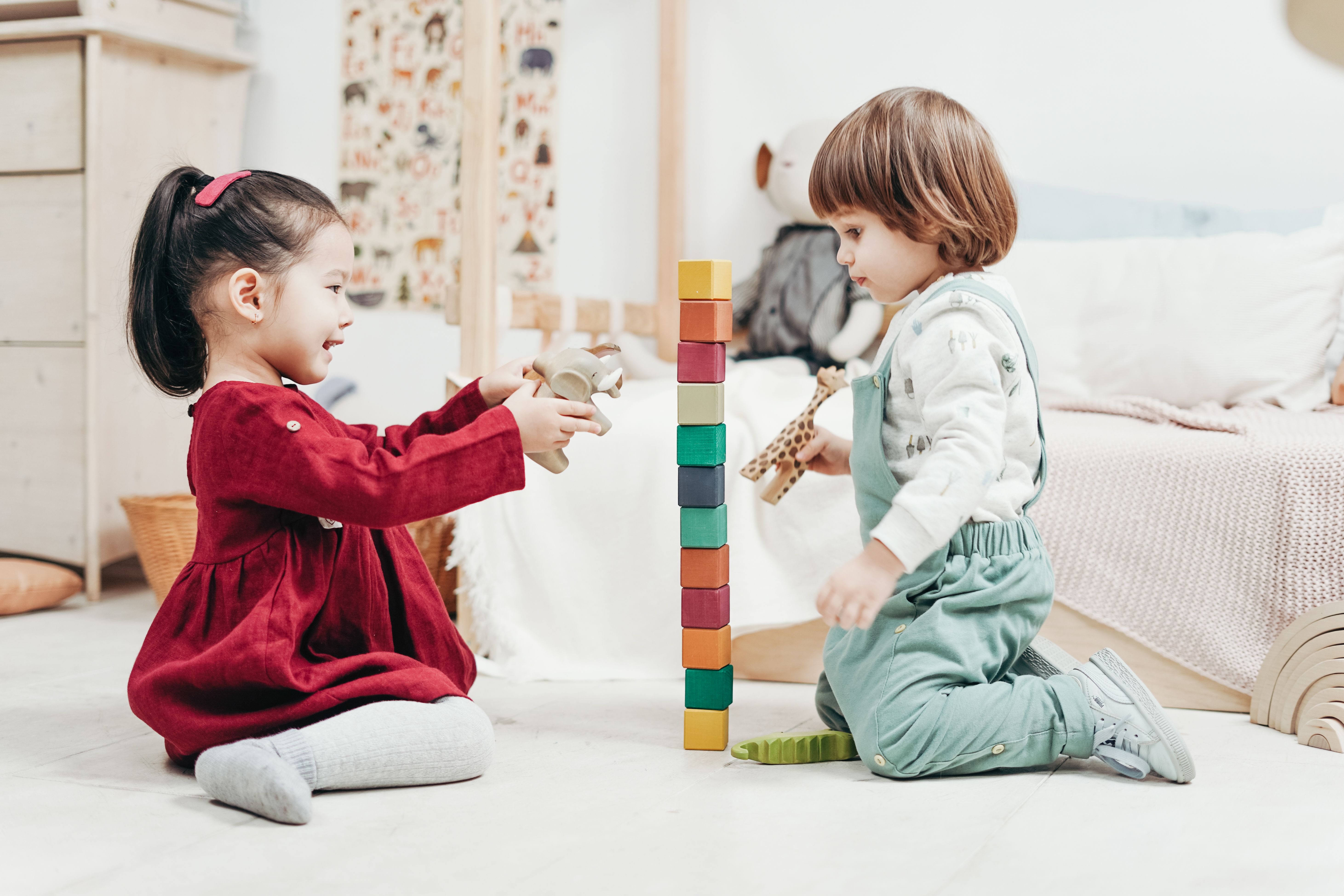Two young children playing with wooden blocks